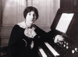 A photograph of Lili Boulanger seat at the harmonium. Copyright musictheoryexamplesbywomen.com
